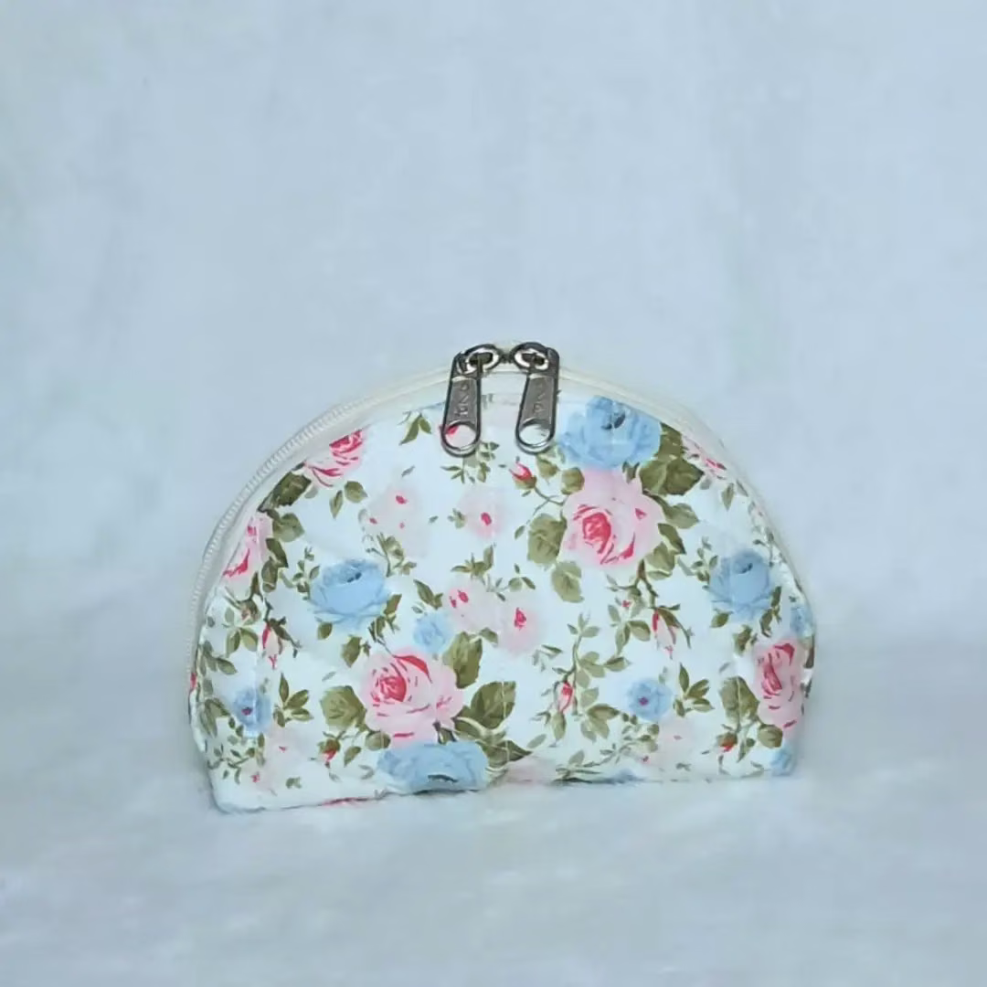 Cosmetiquera media luna de tela floral con cierre
